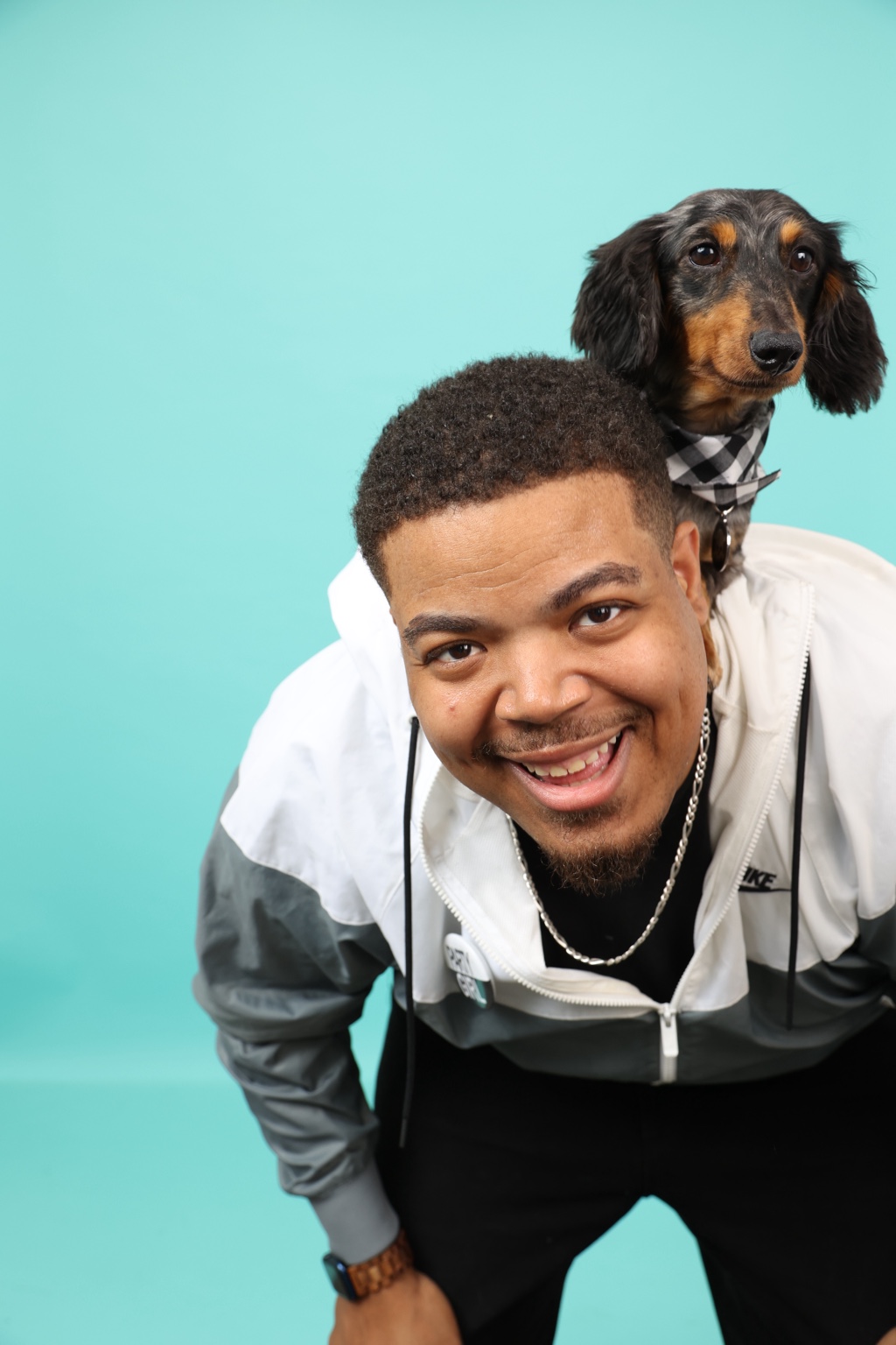 Magic smiles at the camera with his dachshund, Frank, perched on his shoulder